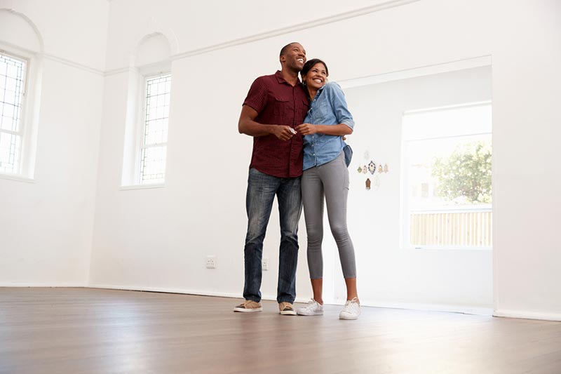 An excited young couple moving into a new home together