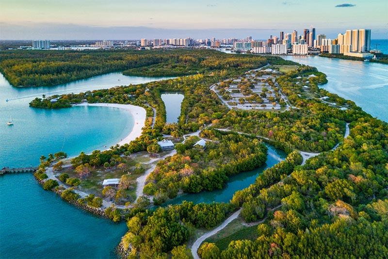 An aerial view of Oleta River State Park, with its winding river paths and greenery, in North Miami