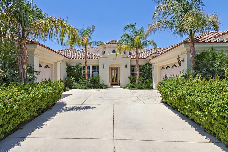 A luxurious home with palm trees in front of it in Palm Springs