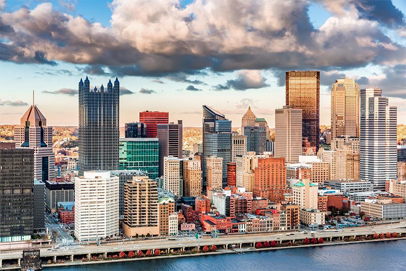 An aerial view of the skyline of Pittsburgh Pennsylvania with a river running in the foreground 