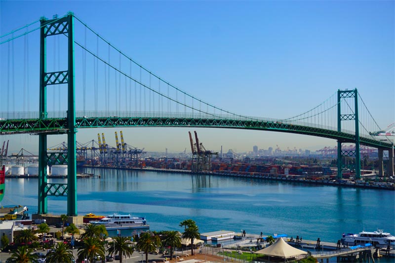 Aerial of Vincent Bridge and San Pedro port with boats and cranes in distance.