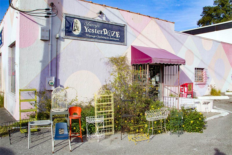 Pink neighborhood shop with various chairs out front.