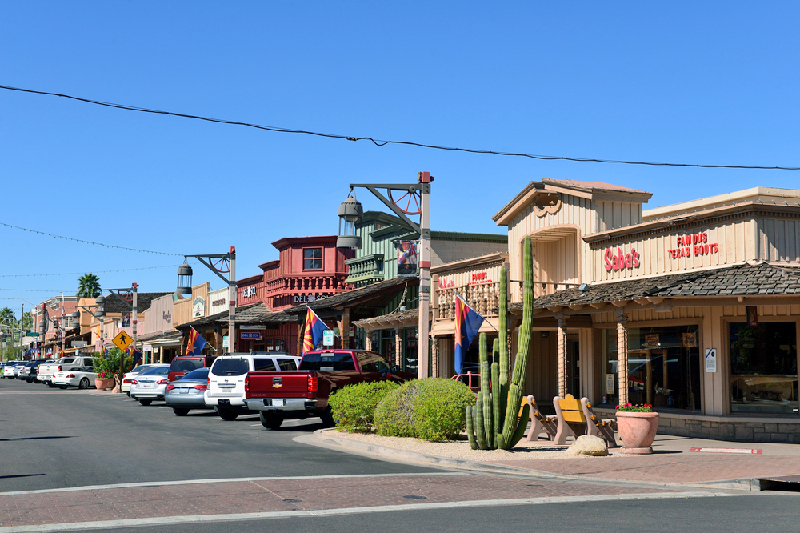 Looking downa  old town street with many shops and businesses.