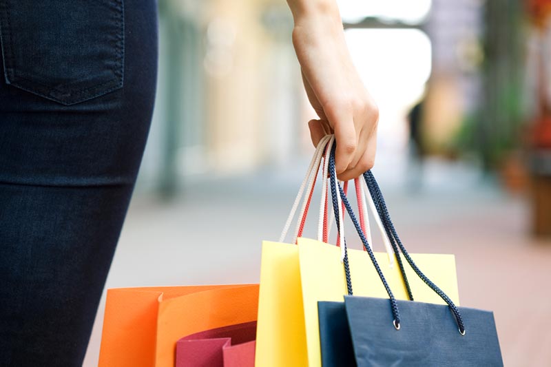 A woman holding a bunch of shopping bags