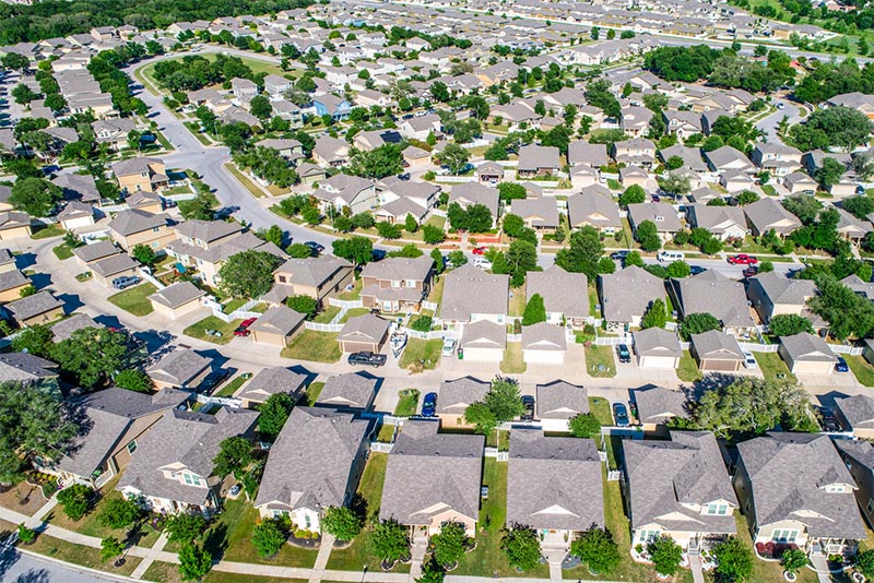 A bird's eye view of a residential area with homes along a street in suburban Texas