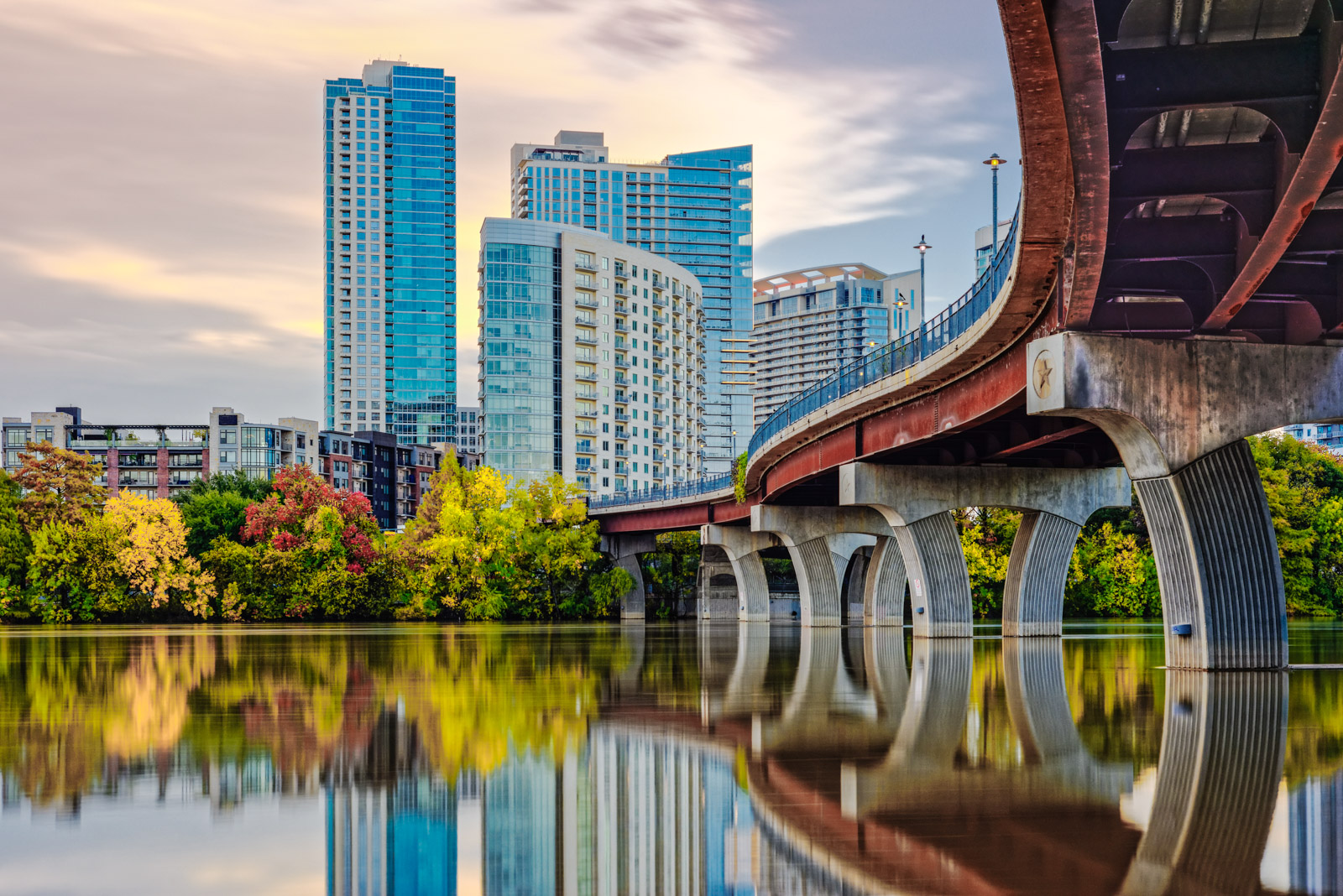 A highway bridge winds into Downtown Austin over a river