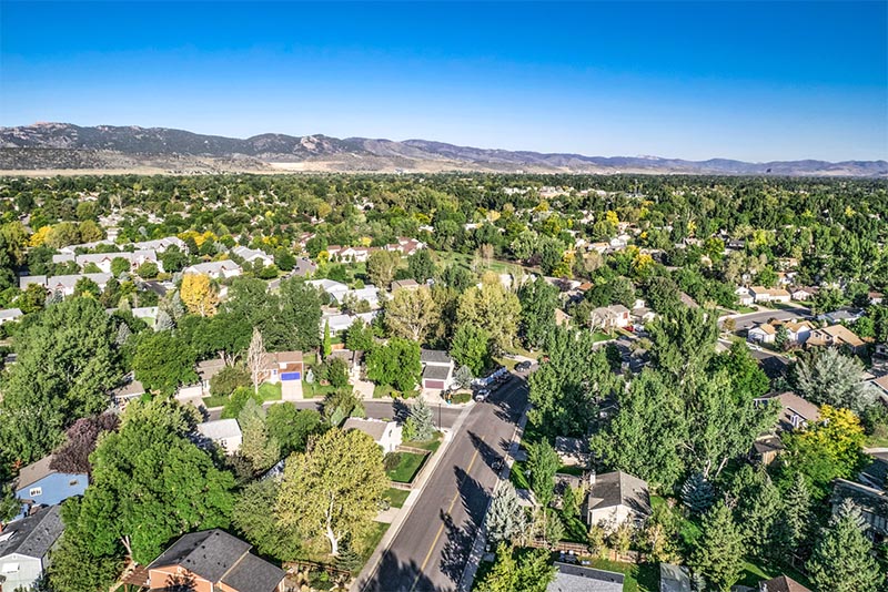 An aerial view of homes in a residential part of Fort Collins with the Rocky Mountains in the background