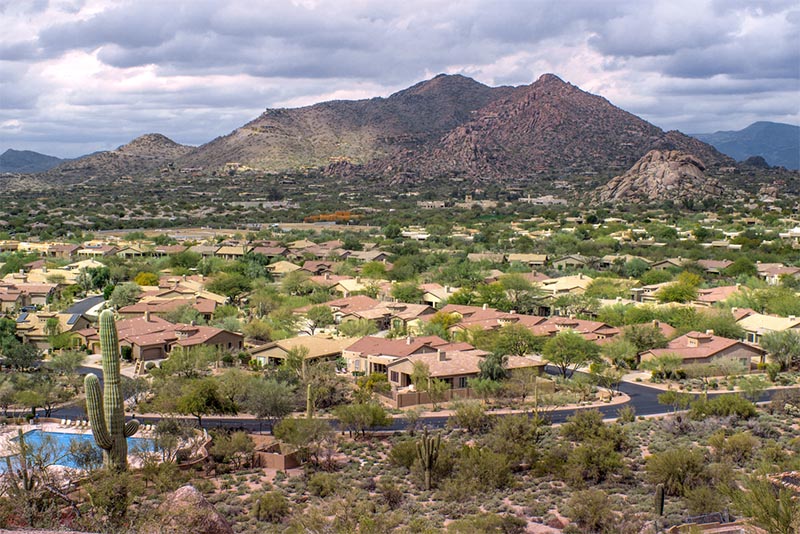 An aerial view of a residential subdivision in Arizona with mountains behind it