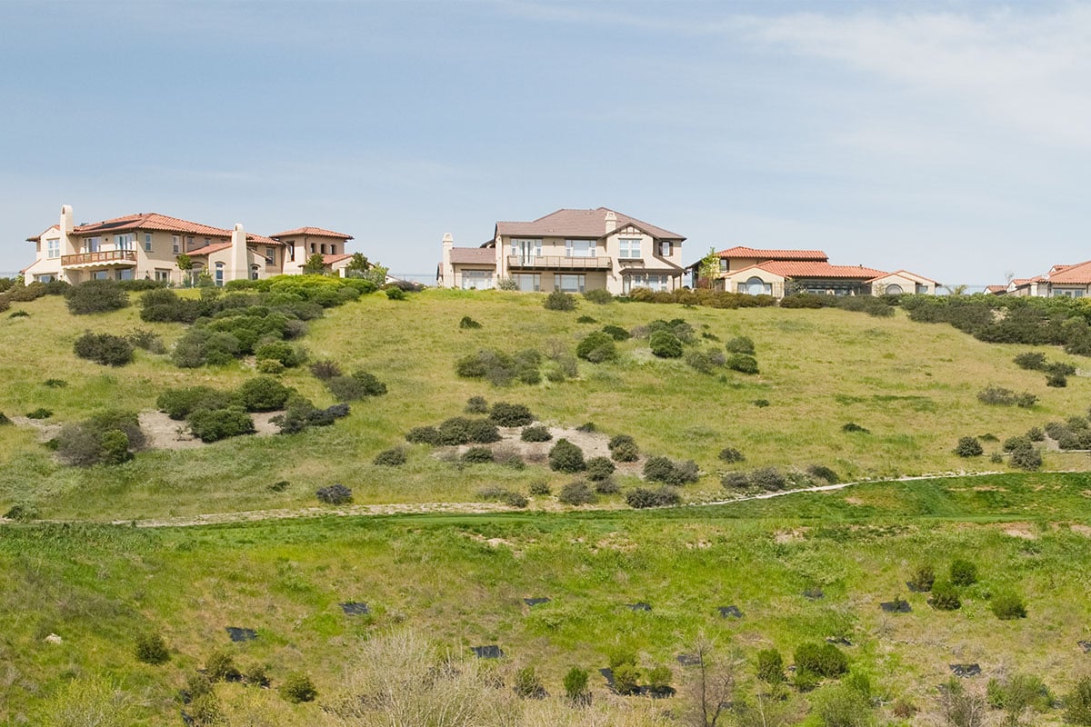 coastal golf course with hillside homes in background