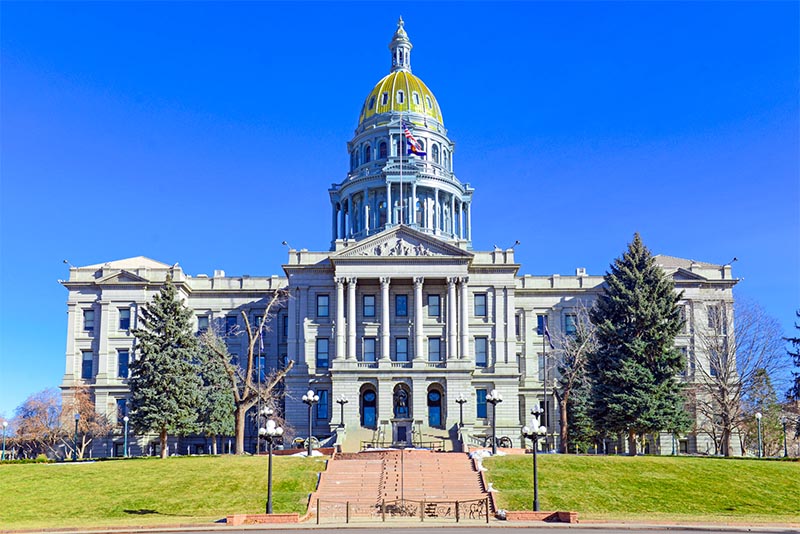 The Denver Capitol Building with its gold dome rises above the surrounding landscape.