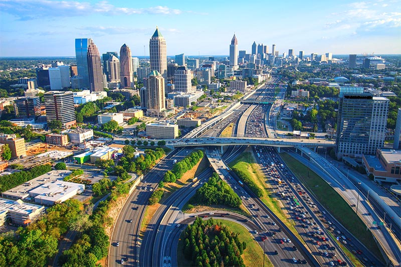 A highway cuts across Downtown Atlanta filled with cars