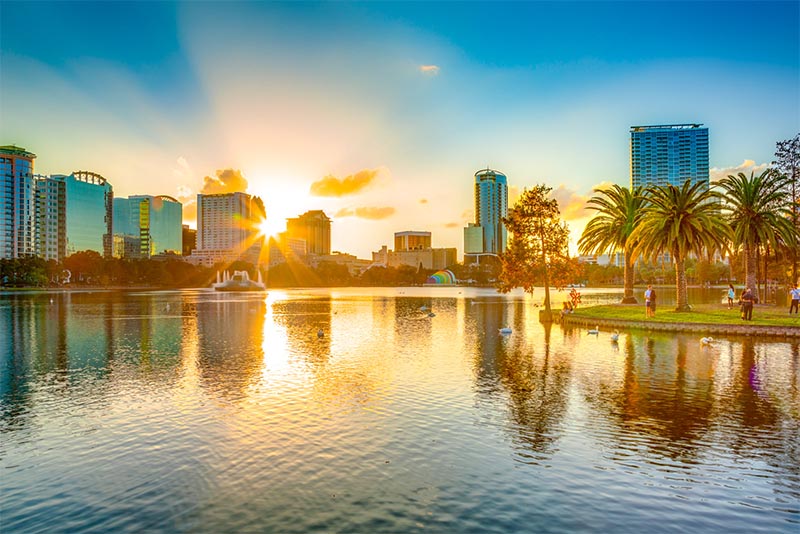 The Orlando skyline at sunset as seen from a park along the water