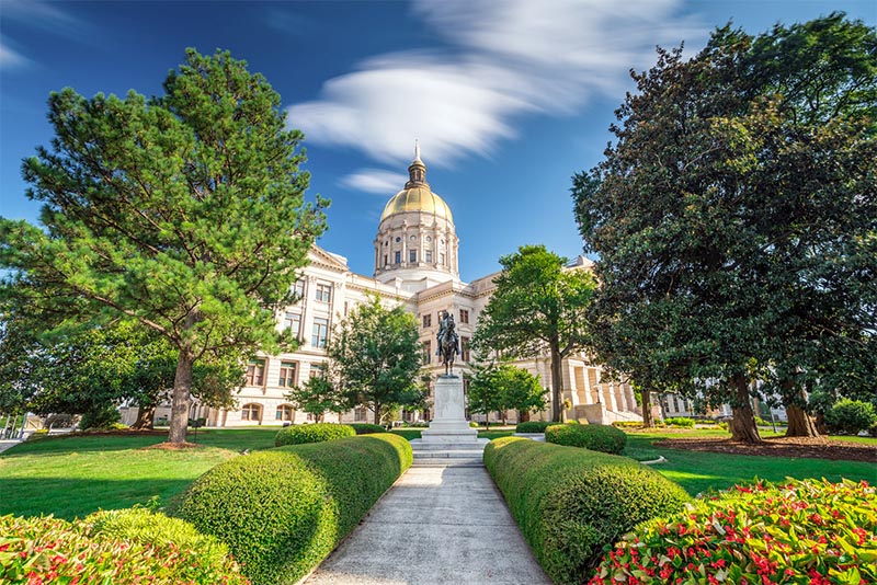 The Georgia State Capitol building with its gold dome and statue just outside