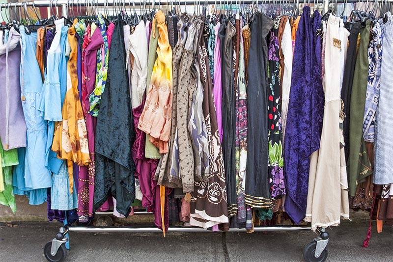 A long rack of clothing outside of a thrift store