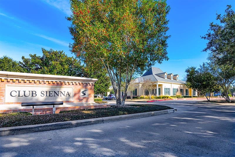 The outside sign and clubhouse of the Sienna community in Texas