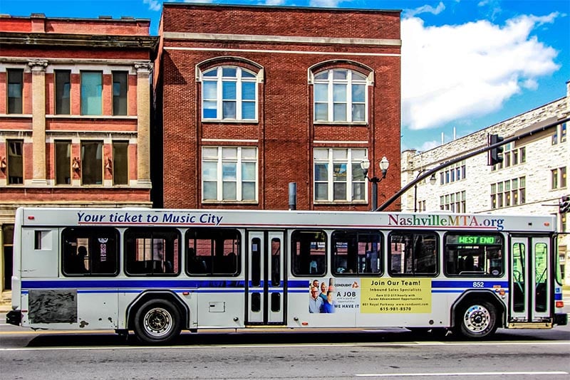 A Nashville MTA bus driving down a SoBro street