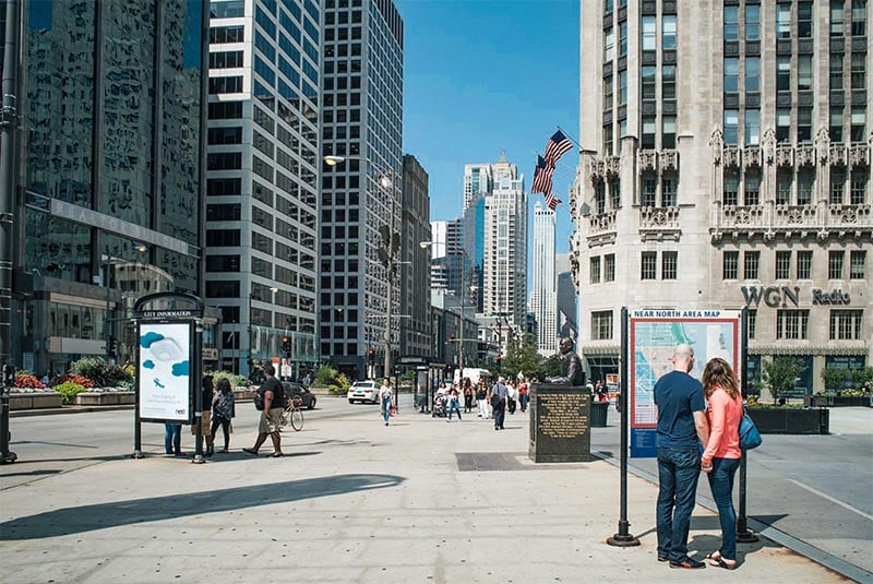 A couple hold hands looking at a map outside the Wrigley Building in Streeterville Chicago