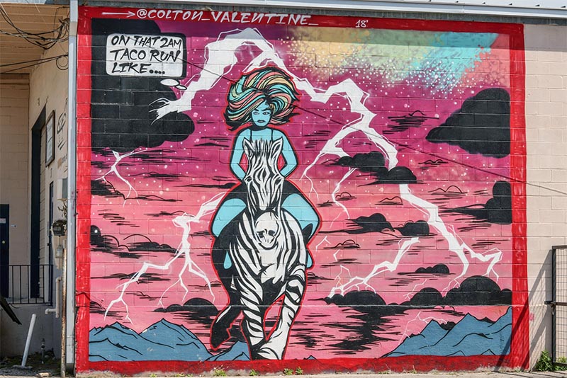 Vibrant mural of a person riding a zebra in San Antonio TX