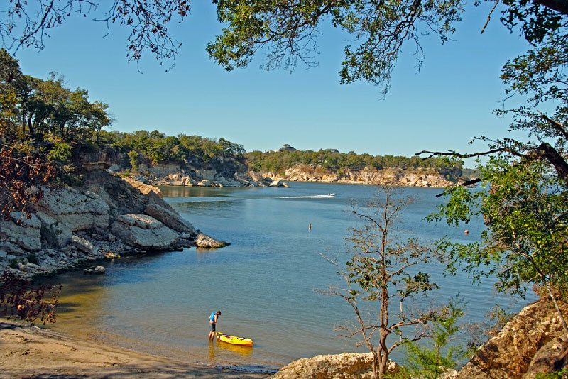 Kayaker heading out to Lake Texoma near beach in Texas.