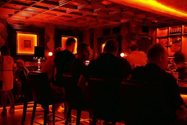 Bar patrons at secret bar in Phoenix, AZ with red llighting.