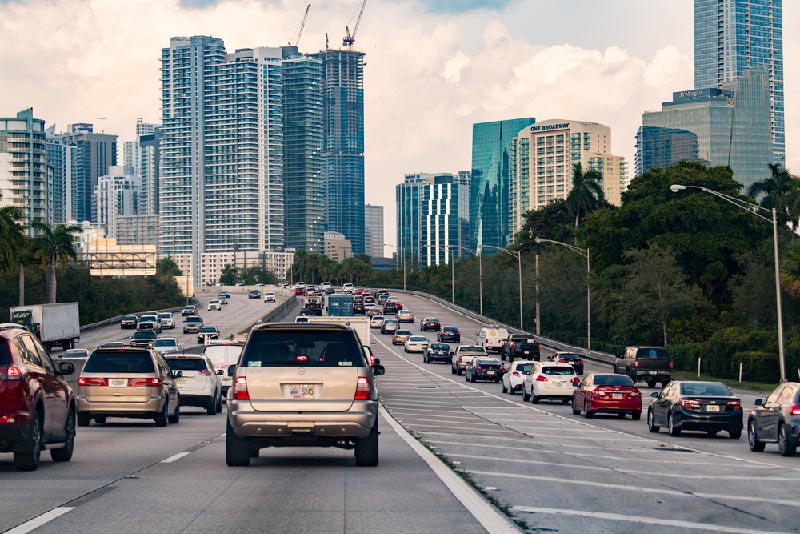 Cars bumper to bumper on the highway heading towards Miami skyline.