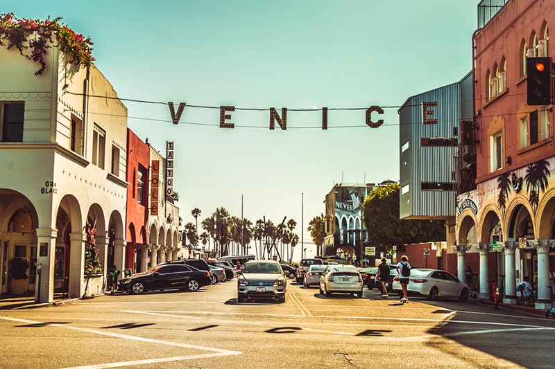 Cars and buildings lining a busy street in the Venice neighborhood in Los Angeles, California
