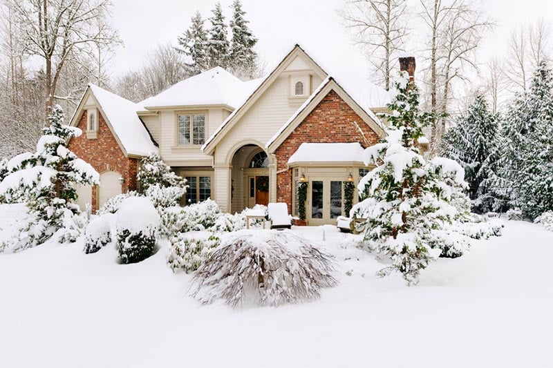 Subruban home made of brick and stucco covered in snow